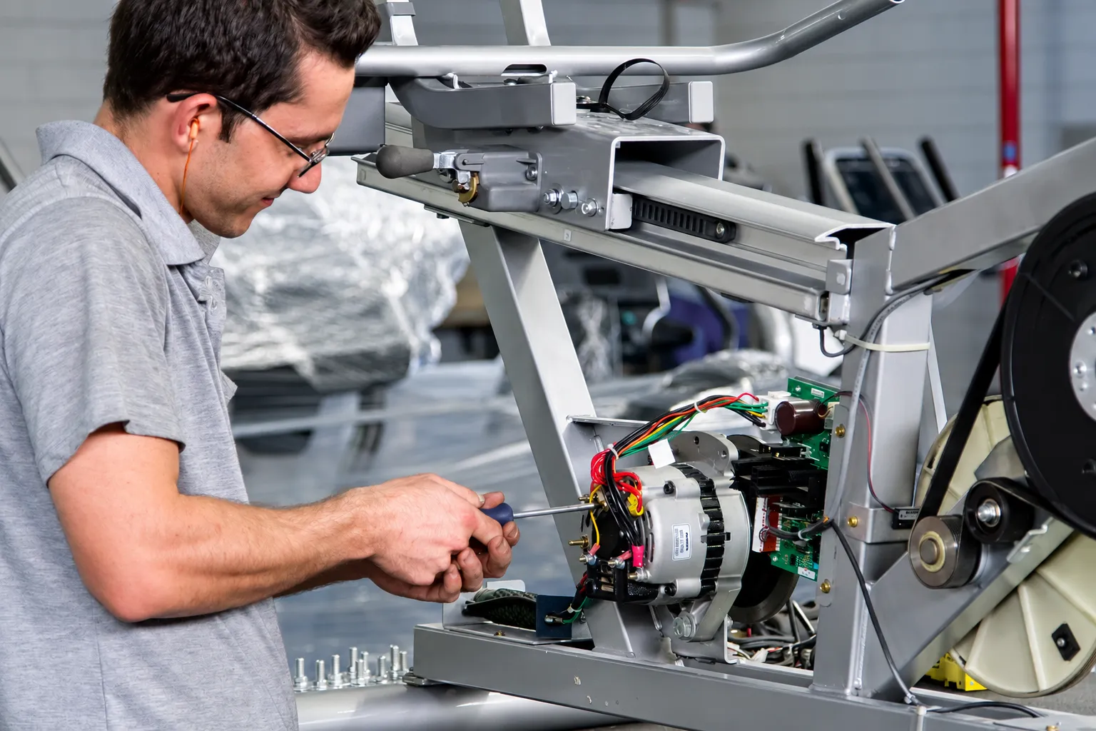 Técnico instalando componentes elétricos em um equipamento de cardio